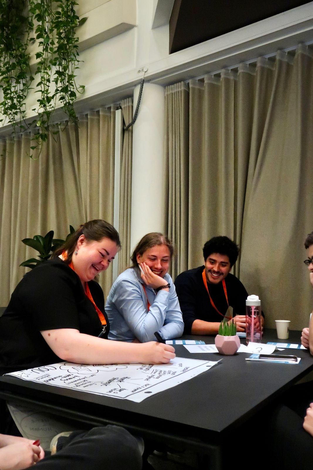 A table of participants laughing together over a flip-chart poster