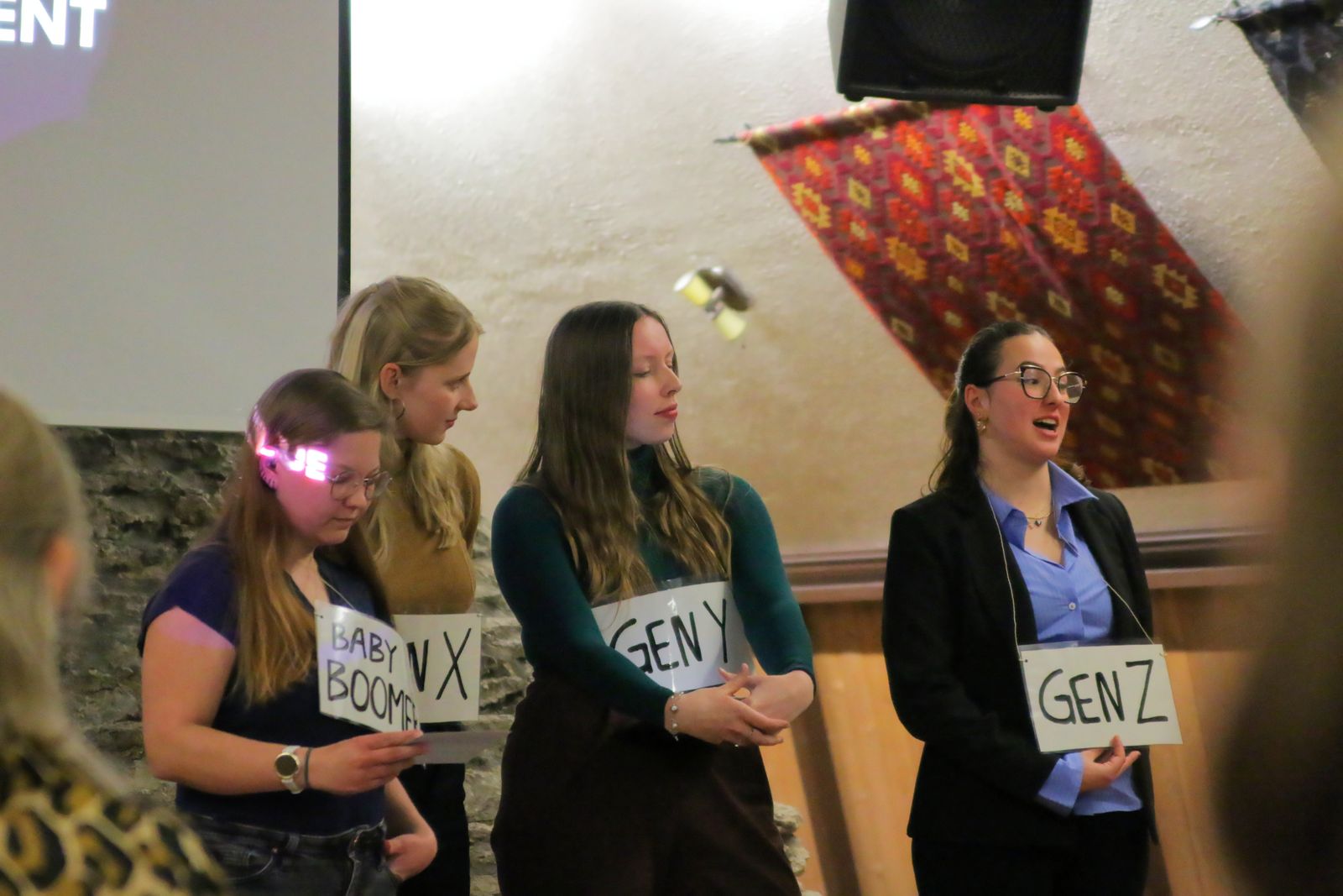 Participants on stage holding generation signs during a playful session